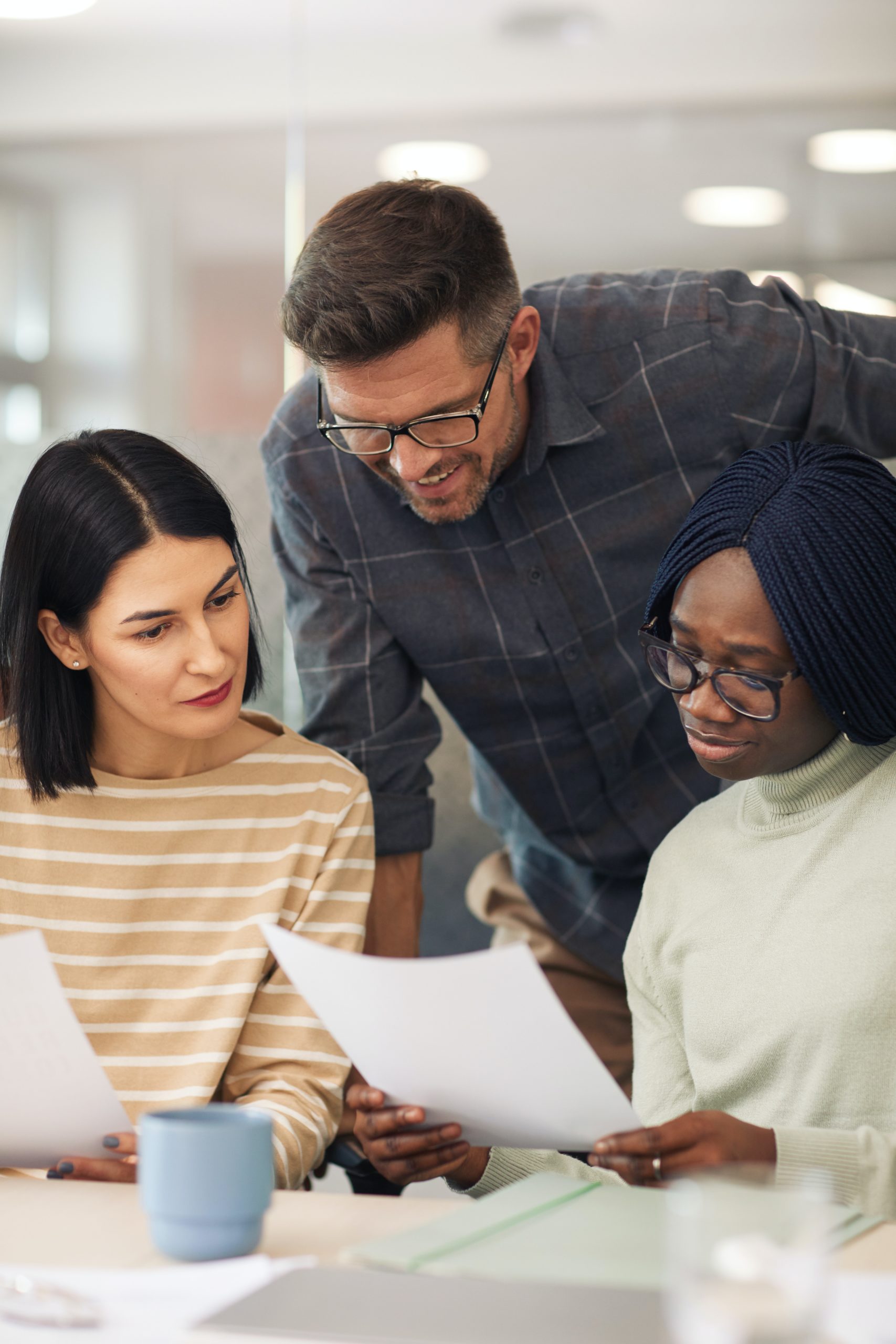 three coworkers looking at papers together