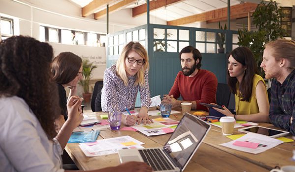 Woman Showing Team Papers At Table Meeting