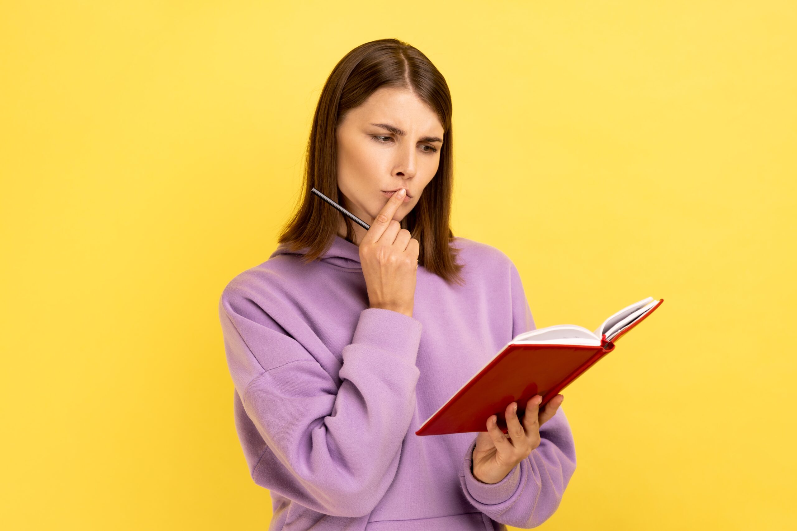 woman holding a notebook and pondering questions